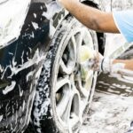 Man cleaning his car with foam