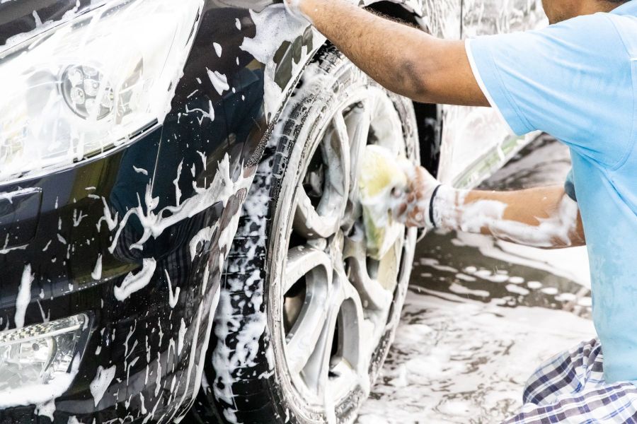 Man cleaning his car with foam