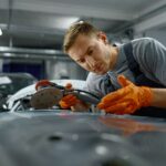 Young mecanician renovating an old car
