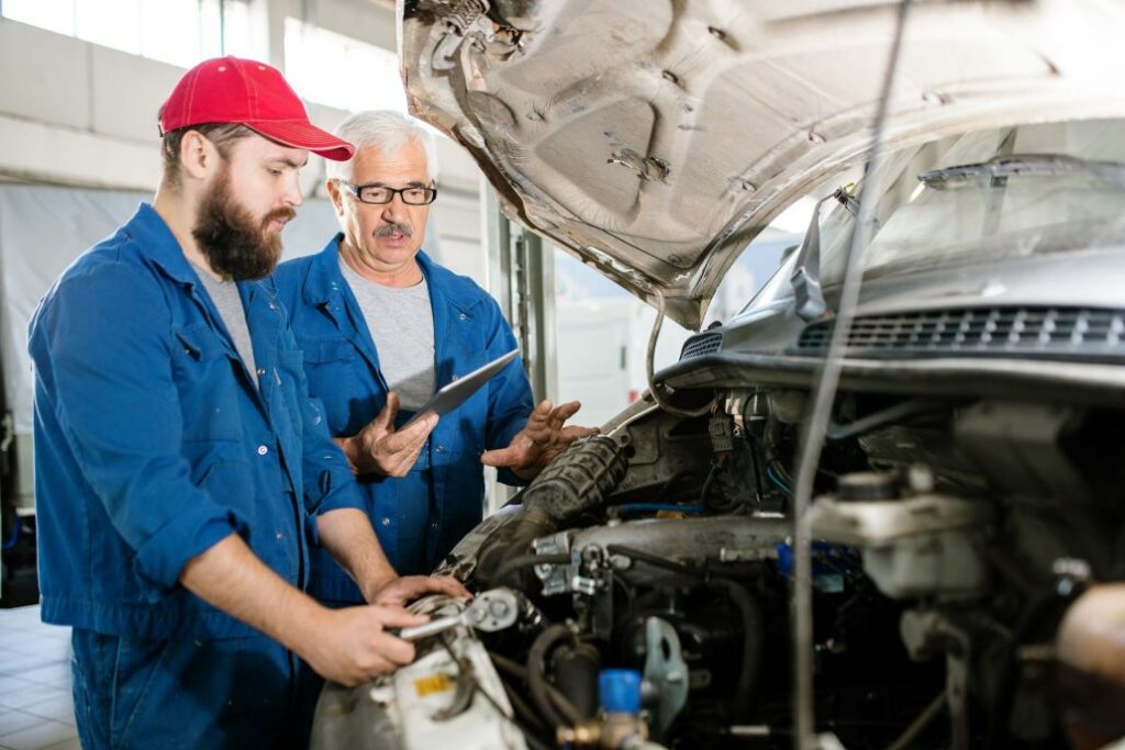 Two mecanicians doing a technical control over a car