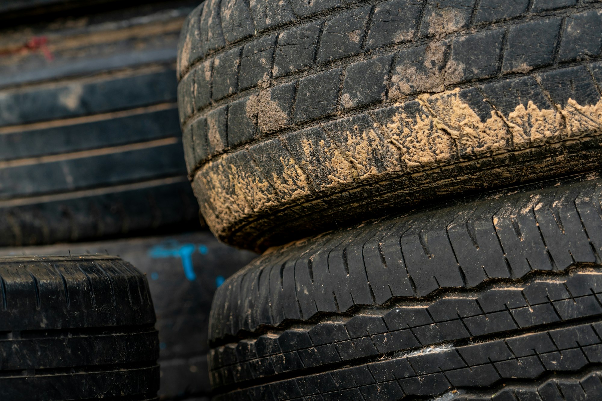 Stack of old tires. Pile of used tires. Black rubber tire of car. Dirty used tyres. Closeup old tyre